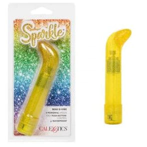 a yellow sparkle vibrator with a straight shaft and a curved pointed tip, shown next to its plastic packaging
