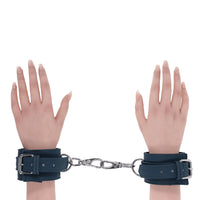 2 hands with green handcuffs on wrists