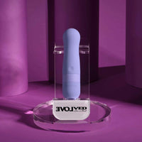 Blue vibrating bullet on a clear stand with 'EvolvEd' branding against a purple background