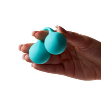 hand holding a set of blue kegel balls