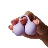 Hand holding a purple silicone kegel balls on a white background