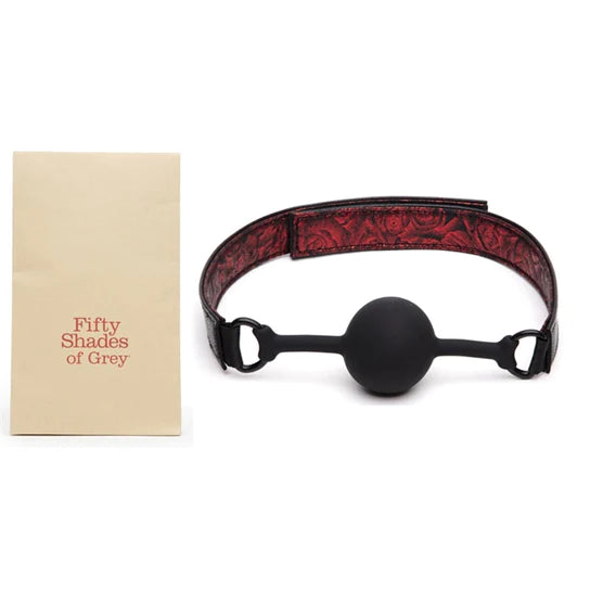 a black ball gag connected to red rose patterned straps. 