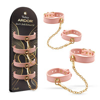 Temptasia Ardor Wrist and Ankle Restraint Set by Blush featuring adjustable pink silicone cuffs with gold-tone chain connectors, shown alongside retail packaging.