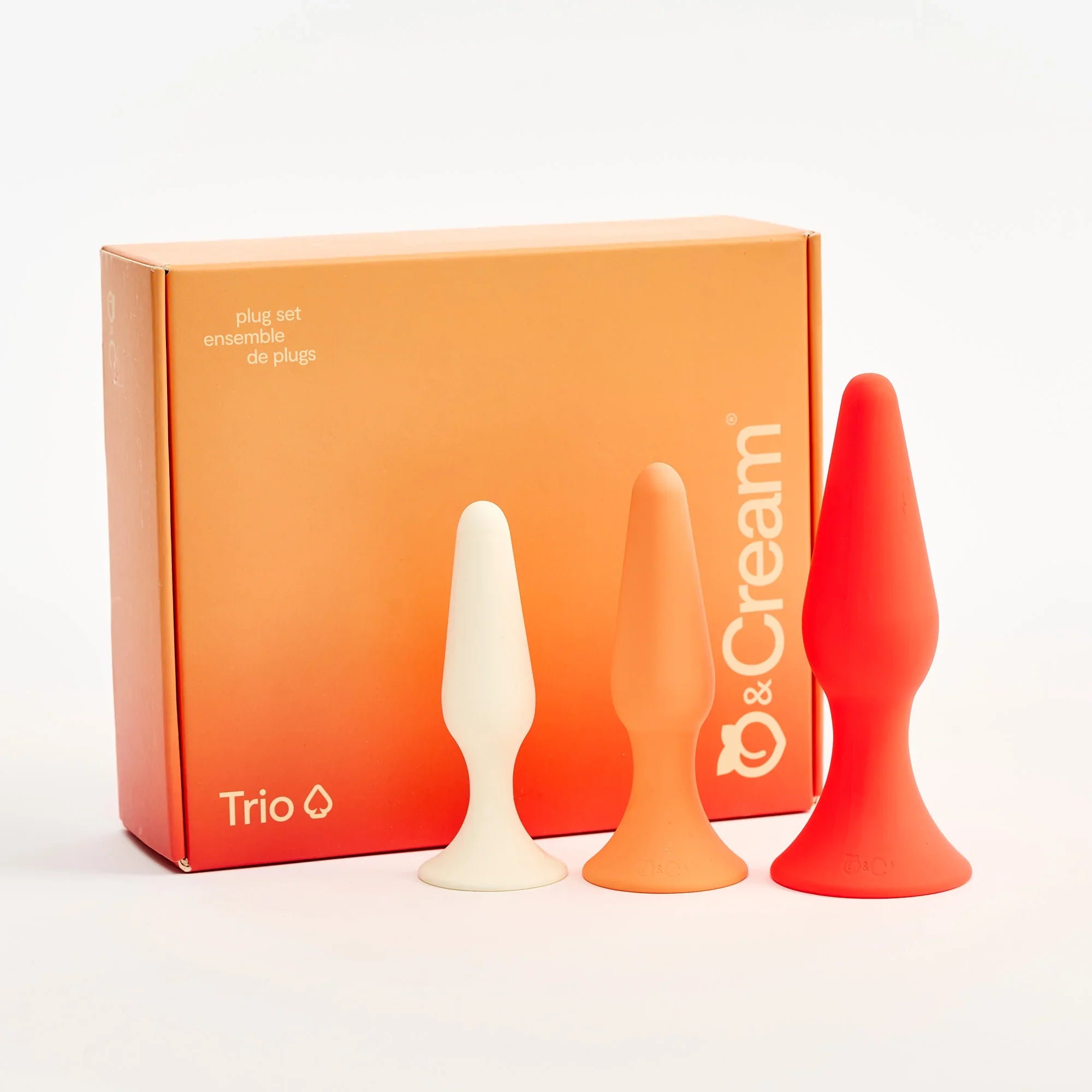 Three silicone plugs in white, orange, and red with a 'Trio' box on a white background.