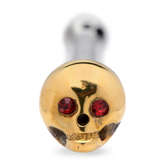 a close up of a golden skull with red gem eyes
