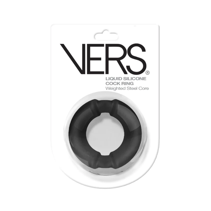 A black liquid silicone cock ring with a weighted steel core, presented in its original white blister packaging with the brand name VERS printed in bold black letters.