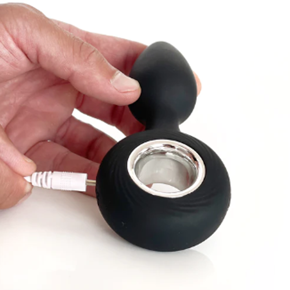 Black silicone product with a white cable being held by a hand on a white background