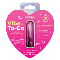 A pink heart-shaped retail package containing a small USB vibrating bullet. The packaging is bright pink with white and yellow text and decorative icons, and the bullet inside is metallic pink.
