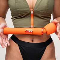 Person holding an orange vim flexible wand with a plain background
