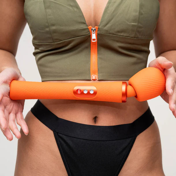 Person holding an orange vim flexible wand with a plain background
