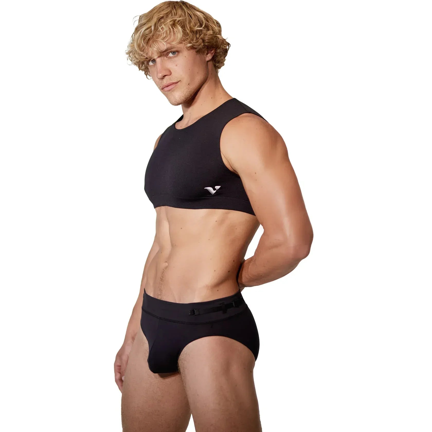a man wearing a mini crop top and jock strap in black