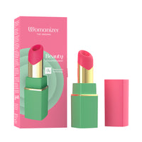 A cosmetic lipstick vibrator product shown with its pink retail box, the lipstick bullet exposed, and the cap standing beside it on a white background. The packaging and product design feature bright pink and mint green, with a metallic gold band.