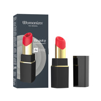 Womanizer Beauty Cervical Stimulator lipstick vibrator shown with its retail box, an open lipstick tube, and the cap on a clean white background.