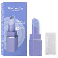 Womanizer Beauty Citoral Stimulator lipstick vibrator shown with its blue packaging box, the open lipstick bullet, and its translucent cap on a white background.