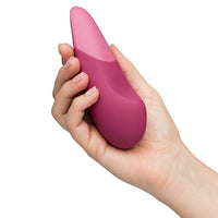 hand holding pink sleek womanizer vibrator