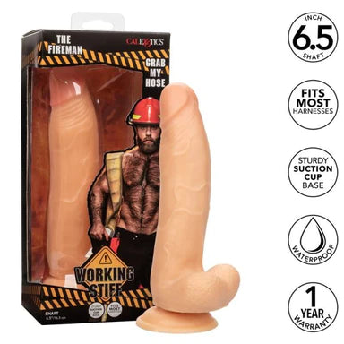 a beige detailed penis shaped dildo with balls and a suction cup. Shown next to its display box the shows a bearded hairy man wearing a helmet and black pants