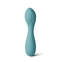 A teal silicone personal massager with a curved handle and concentric circular design on the head, shown against a plain white background.
