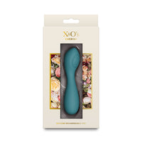 A teal silicone rechargeable vibrator in its original cream-colored packaging with floral accents and the brand name 'X&O's Cherish' printed on the front.