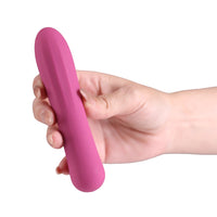 A hand holding a pink, smooth, curved personal massager against a plain white background.
