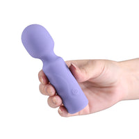 A hand holding a lavender purple silicone personal massager wand against a solid white background.