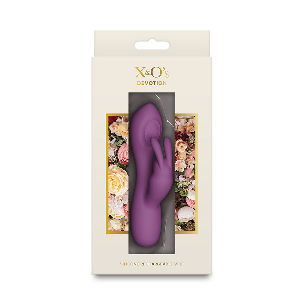A purple silicone rechargeable vibrator with clitoral stimulator by X&O's Devotion, shown inside its cream-colored retail packaging with floral accents.