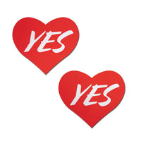 red heart pasties with the word yes written in white