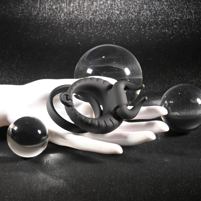 bull cock ring held in hand, beside bubbles