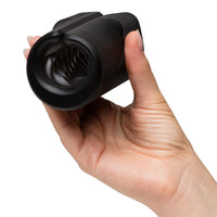 Hand holding a black zing masturbator against a white background