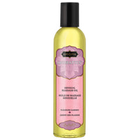 A bottle of Kama Sutra Aromatic Massage Oil with a label that has a pink and green color scheme and text indicating it is for 'Pleasure Garden'.