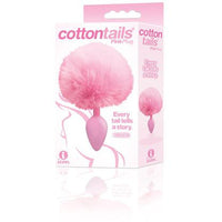 The product image shows the packaging of the Cotton Tails Anal Plug, with the plug itself visible. The plug is pink, with a fluffy white fur attachment, and is shown in a clear plastic package with branding and product information.