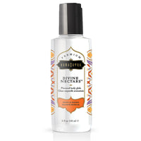 A bottle of Kama Sutra Divine Nectars Body Glide in Tropical Mango flavor. The bottle is clear with a label featuring mango graphics and product information.