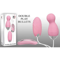 The image shows a set of two pink vibrating bullets, one with a ball-top shape and the other egg-shaped. The set includes a wired remote controller and comes in a box labeled 'Double Play Bullets'.