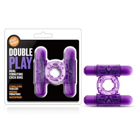 The image shows a purple vibrating cock ring with dual bullet vibrators. The product is displayed both in and out of its packaging, highlighting its features and giving a clear view of its design and color.