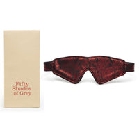 A red and black padded faux leather blindfold with a rose-print design, displayed next to its packaging that reads 'Fifty Shades of Grey'.