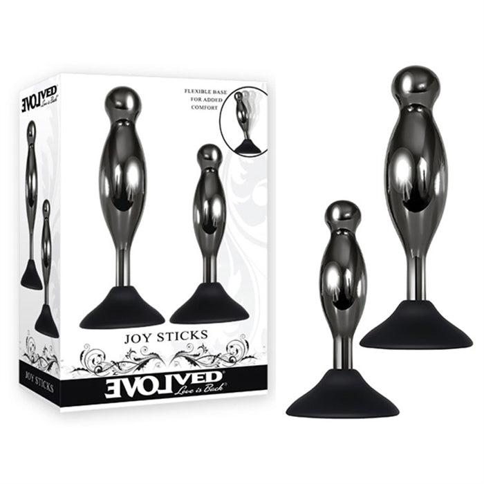 The product image shows a two-piece anal plug set with black chrome-finished alloy shapes and a suction cup base. The set is displayed alongside its packaging, which features the name 'Joy Sticks' and the brand 'Evolved'.