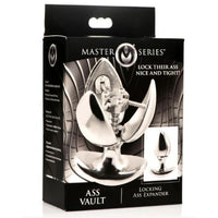 The product image shows the packaging of the Master Series Ass Vault Locking Ass Expander. The box features a black and silver design with images of the stainless steel anal plug and the key, emphasizing its locking mechanism and temperature sensitivity.