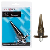 The product image shows the Mini Vibro Tease Vibrating Anal Plug in a clear, transparent casing with a silver-plated vibrating stimulator. It is packaged in a blue and white card with the product name and features listed.