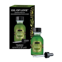 The product image shows the packaging and bottle of Oil of Love Warming Kissable Body Oil. The packaging is predominantly green with floral patterns, and the bottle is small with a dropper.