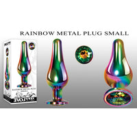 The image shows a small, rainbow-colored metal anal plug with a tapered tip and a sparkling gem at the base. The plug is displayed in different angles and includes a picture of it packaged in a box.