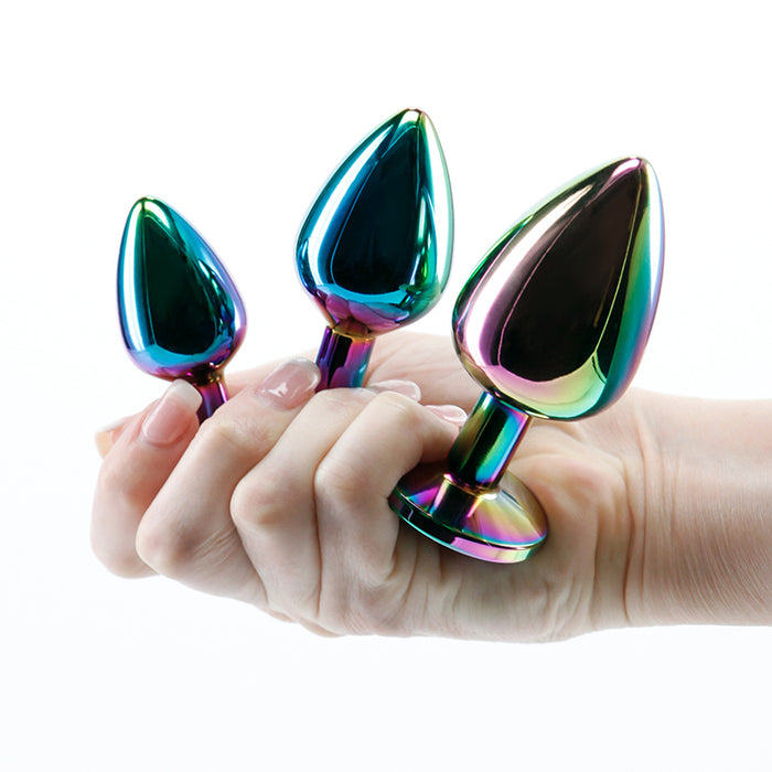 3 metal anal plugs being held in a hand, on a white back ground