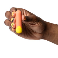 orange vibrating bullet held in hand on white background