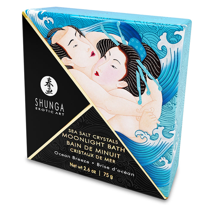 A square container of Foaming Scented Dead Sea Salt with a graphic of a woman in a bathtub on the label, alongside a blue starfish and a scoop of blue salt crystals.