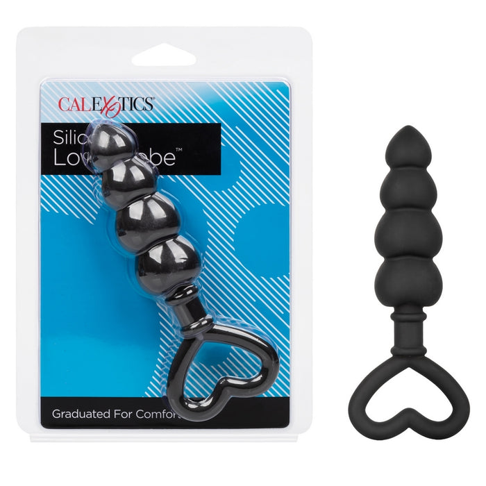 A black anal plug with a tapered, tiered shaft and a heart-shaped finger loop. The product is shown both in and out of its packaging.