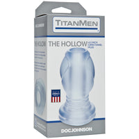 The product image shows the packaging of the TitanMen The Hollow Open Up Anal Plug by Doc Johnson. The box is predominantly grey with a clear window displaying the anal plug inside, which is transparent and seems to be made of a smooth, cushioned material.